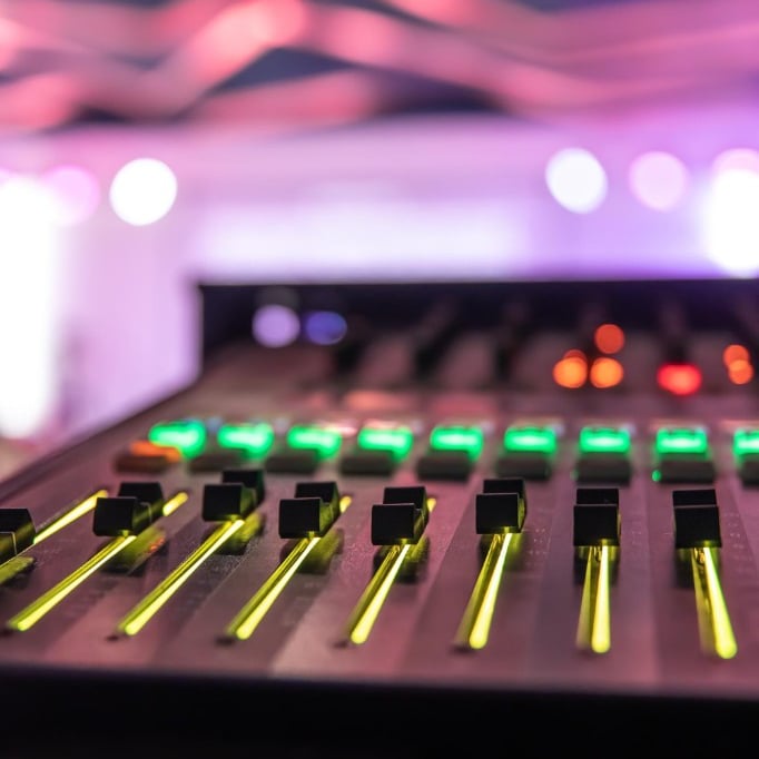 Mesa com faders acesos durante o show