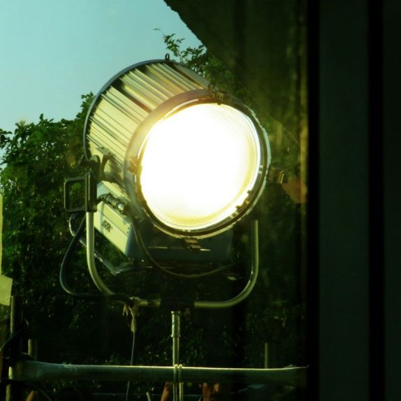 Refletor aceso ao ar livre, com céu e folhagem